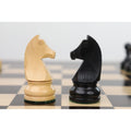 Ebonised boxwood and natural boxwood knights facing off on a checkered tournament chessboard.