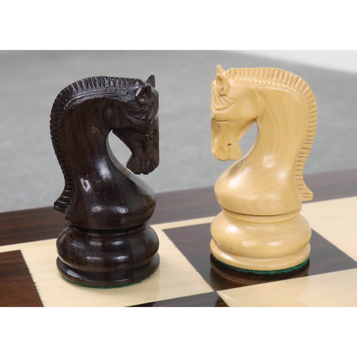 Pair of rosewood and boxwood Leningrad Staunton knight pieces on a chessboard.