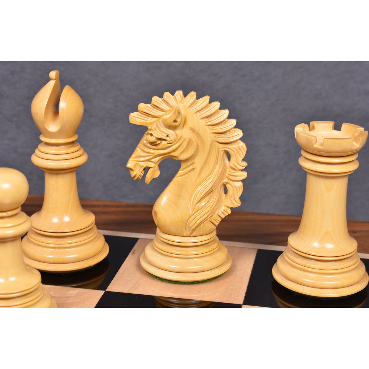 Close-up of light wood Mogul Staunton chess pieces.