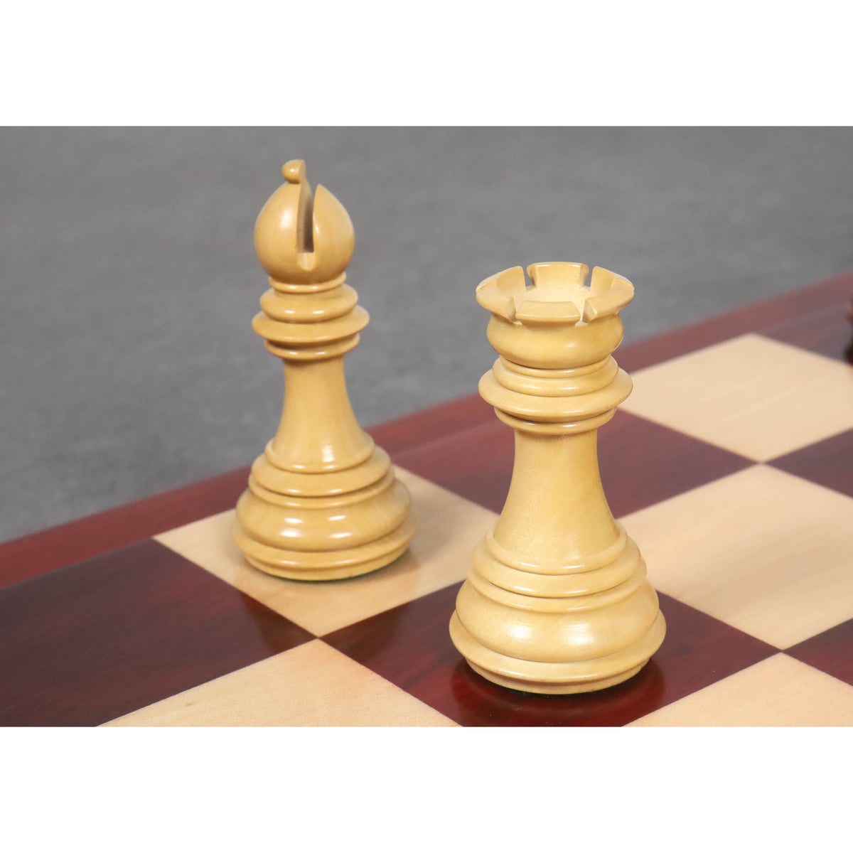 Light boxwood bishop and rook from the Imperial Staunton chess pieces resting on a chessboard.