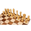 Light boxwood minimalist Berliner chess pieces arranged neatly on a wooden chess board.