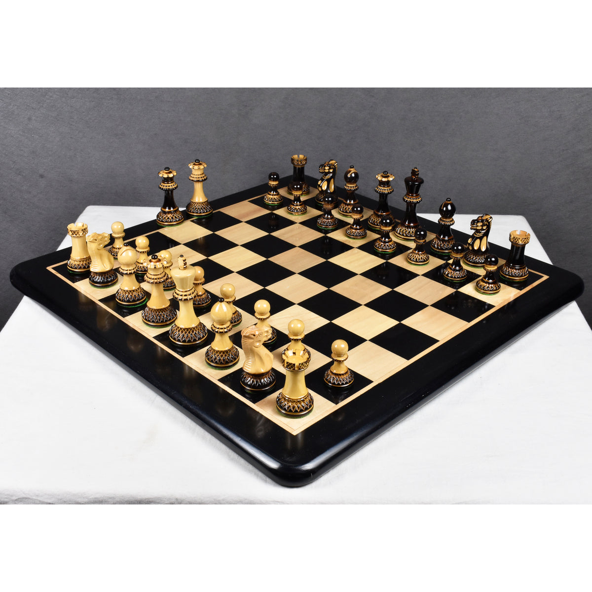 Complete 3.9 inch Parker Staunton carved chess set set up for a game on a premium high gloss chessboard.