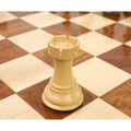 Close-up detailing the battlements of a boxwood British Staunton rook resting on a chessboard.