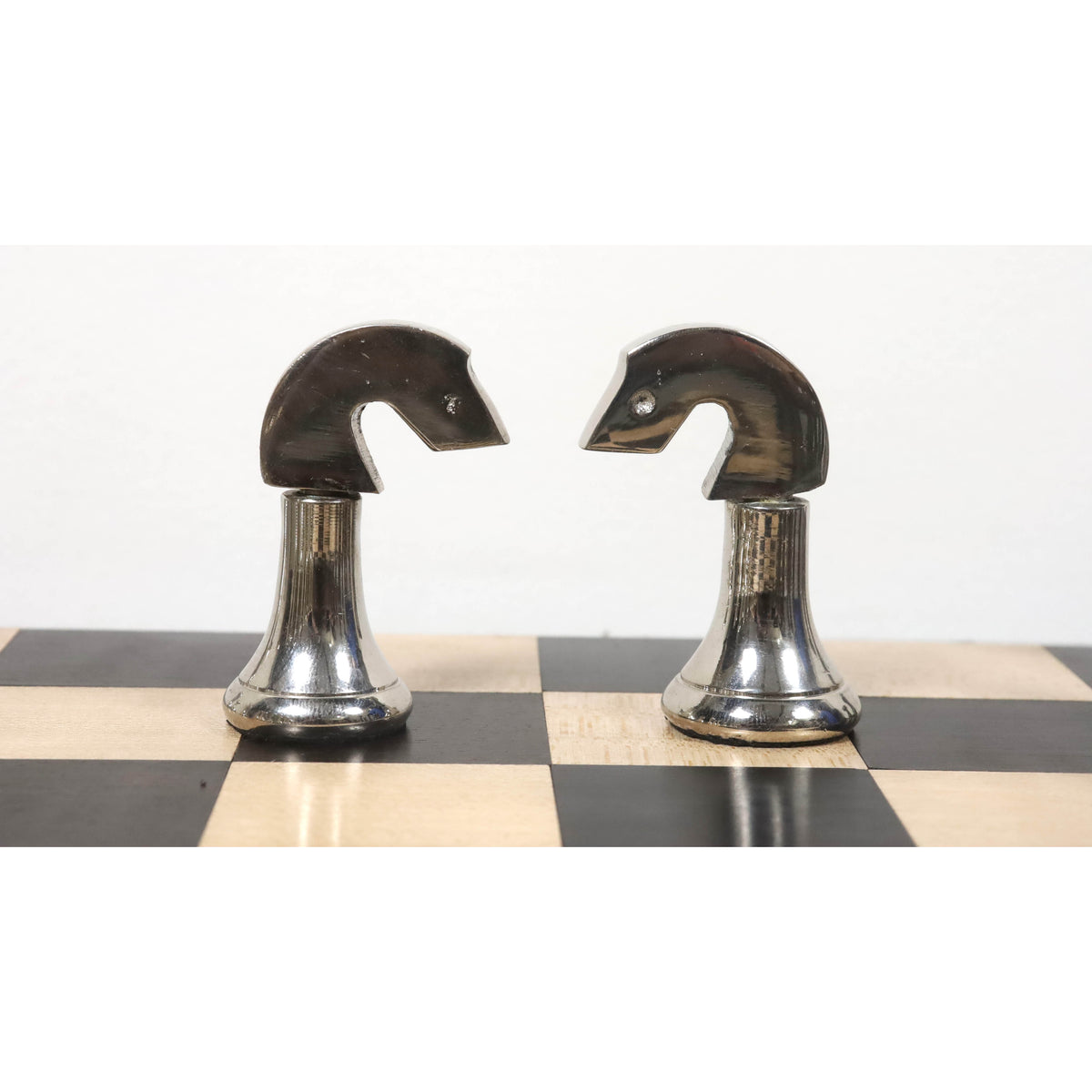 Pair of silver brass chess knights featuring a minimalist contemporary artistic design.