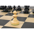 A single natural boxwood W.T. Pinney Staunton pawn resting on a wooden chessboard square.