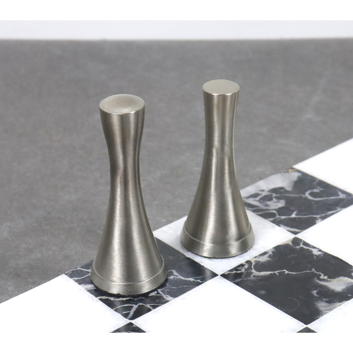 Two silver finished metal chess pieces showing the sleek, modern aesthetic of the Tower Series.