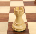 Close-up of a single boxwood rook from the Reykjavik Series Staunton chess set on a board.