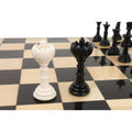 Side view of black and white Turkish Tower queen pieces on a chessboard