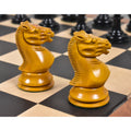 Two antiqued boxwood 1852 Harrwitz Staunton knights resting on a wooden chessboard.