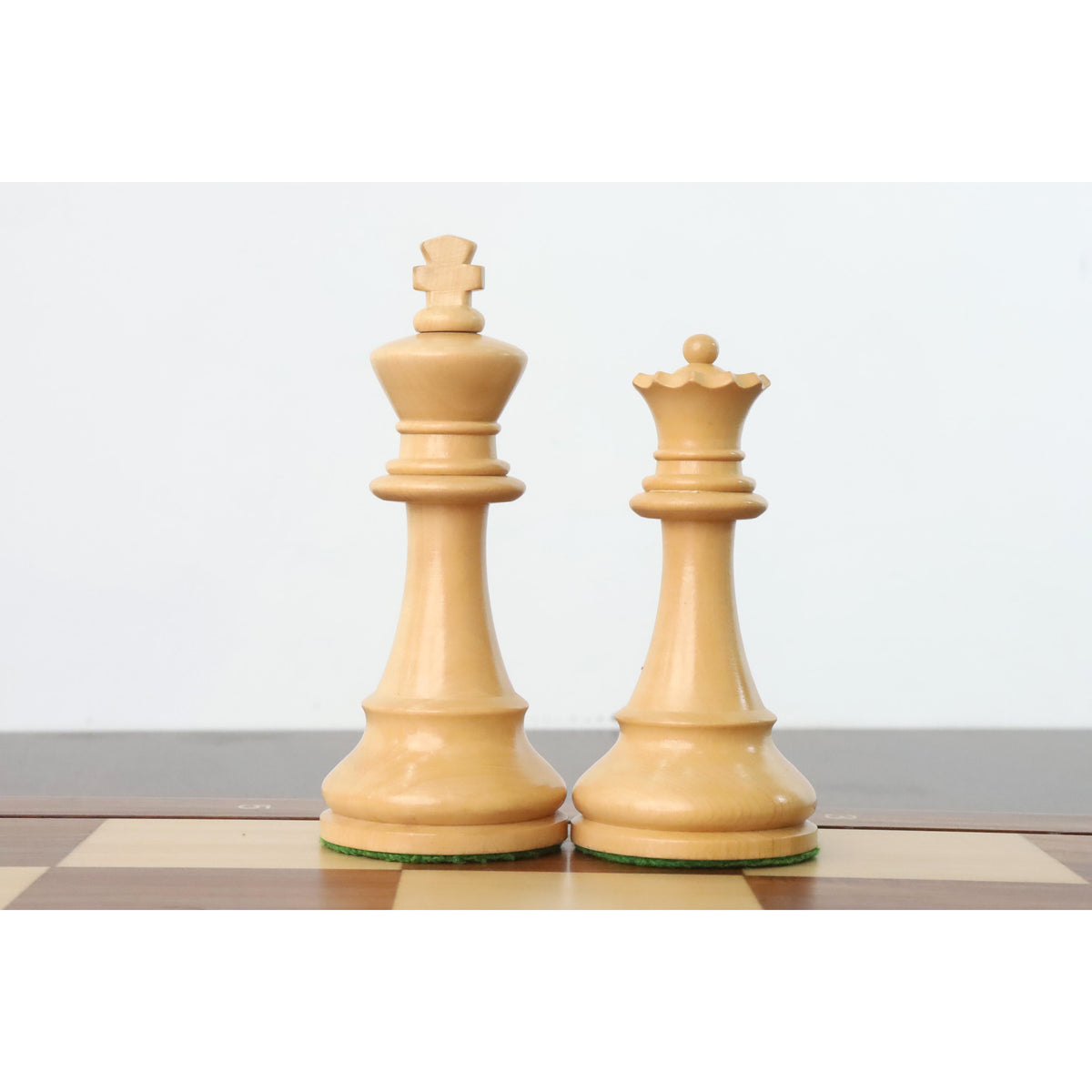 Boxwood French Grandmaster king and queen chess pieces on a wooden board.