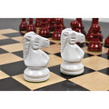 Close-up of two white lacquered boxwood Prime Staunton knights on a chessboard, with burgundy pieces blurred behind them.