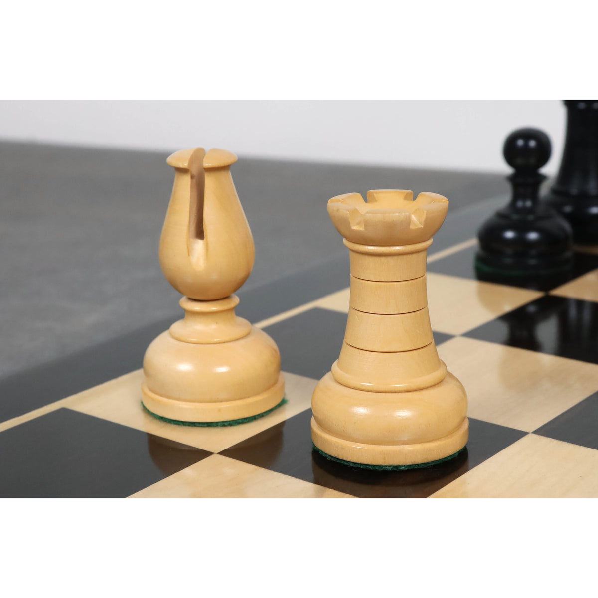 Intricately carved white boxwood Bishop and Rook pieces highlighting the Library Series aesthetic.