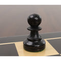 Close-up of a single ebonised boxwood bishop from the Reykjavik Series Staunton chess set on a board.