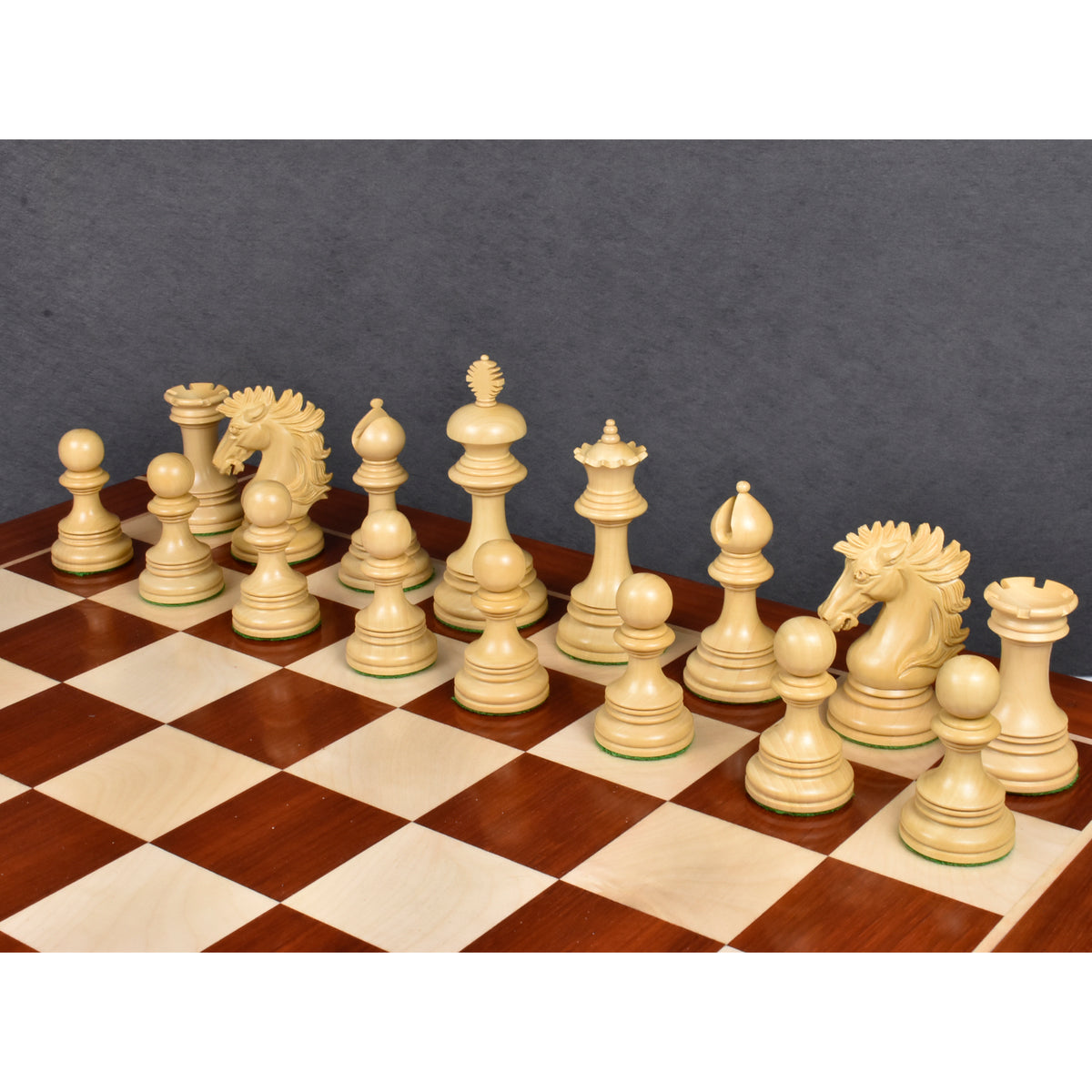 Natural boxwood Alexandria Staunton pieces standing on a premium wooden chessboard.