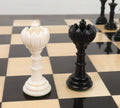 Black and white Turkish Tower queen chess pieces displayed on a board