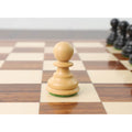 Single weighted natural boxwood pawn from the Russian Zagreb chess pieces set on a wooden board.