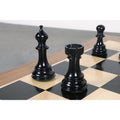 Detailed view of the ebony Staunton bishop and rook positioned on a wooden chess board.