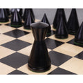 3.1 inch ebonised boxwood Queen piece featuring a sleek minimalist silhouette on a wooden board.