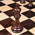 Close-up of two light boxwood Imperial Staunton knights standing side-by-side on a chessboard.