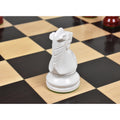 Detailed rear view of a white lacquered boxwood Prime Staunton knight resting on a wooden chessboard.