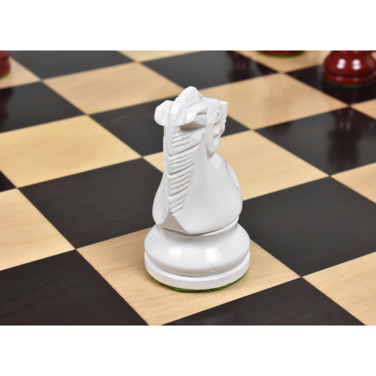 Detailed rear view of a white lacquered boxwood Prime Staunton knight resting on a wooden chessboard.