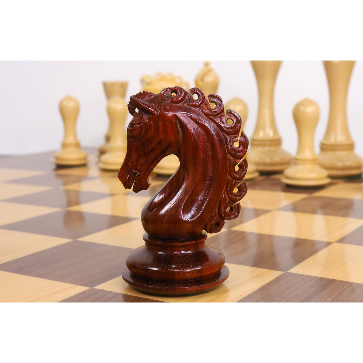 Side profile of an expertly carved bud rosewood knight chess piece.