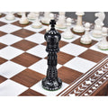 Hand-carved black camel bone king chess piece on an inlaid wooden board.