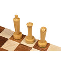 Modern minimalist boxwood king, queen, and bishop chess pieces on a wooden board.
