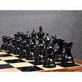 Triple weighted ebony wood Napoleon luxury Staunton chess pieces arrayed on a glossy board.