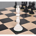 White antique pre-Staunton bishop chess piece on a wooden chessboard.