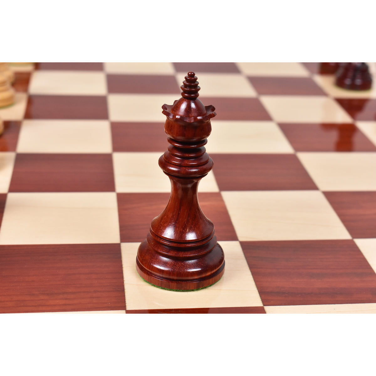 Close-up view of a dark bud rosewood Staunton queen piece.
