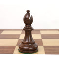 Single weighted golden rosewood bishop from a classic Staunton chess set on a wooden board.