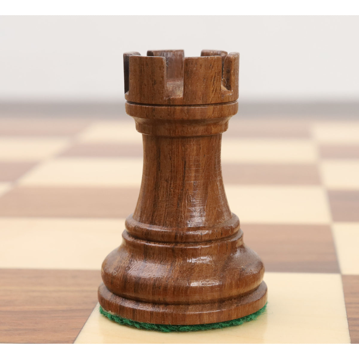 Close-up of a single golden rosewood bishop from the Reykjavik Series Staunton chess set.