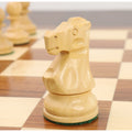 Close-up profile of a single boxwood knight from the Reykjavik Series Staunton chess set on a board.
