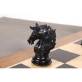 A detailed profile view of a handcrafted ebony Staunton knight on a wooden chessboard.