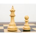 White queen and pawn from the 3.7" British Staunton chess set shown closely on a wooden board.