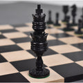 Intricately carved black dyed king from the Lotus Series camel bone chess set on a board.