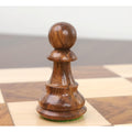 Detailed view of a weighted golden rosewood British Staunton pawn placed on a chessboard.