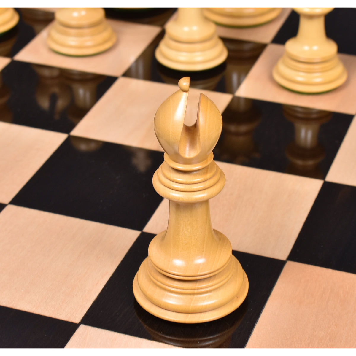 Light wood Mogul Staunton bishop standing on a luxury chessboard.