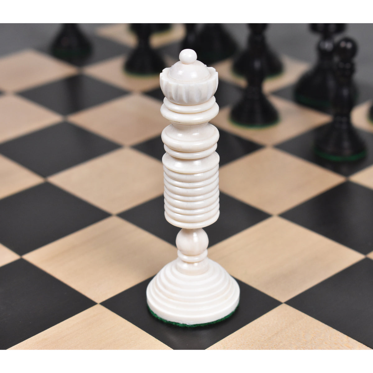 White antique pre-Staunton queen chess piece on a wooden chessboard.