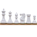 Set of white painted Pro Staunton weighted chess pieces on a wooden surface.