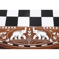 Close-up of handcrafted white acrylic elephant inlay on a premium golden rosewood chess table border.