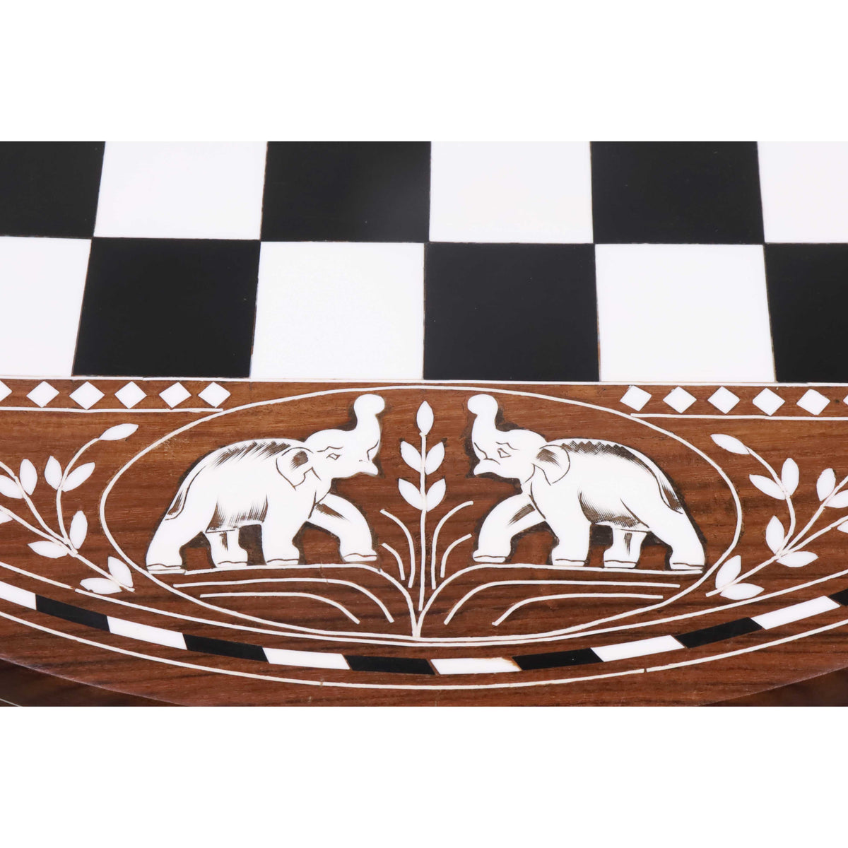 Close-up of handcrafted white acrylic elephant inlay on a premium golden rosewood chess table border.