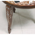 Detailed view of a hand-carved chess table leg featuring intricate white floral acrylic inlay patterns.