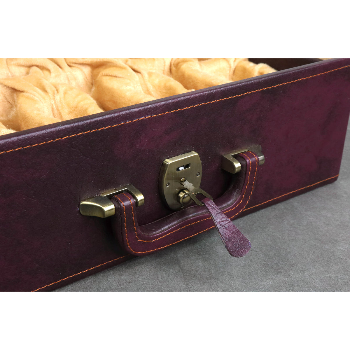 Close-up of the brass lock and key on the deluxe burgundy chess coffer box.