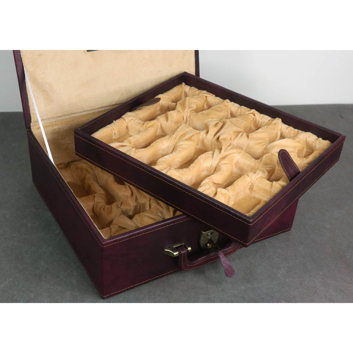 Dual-tier burgundy leatherette chess coffer box showing layered interior compartments.