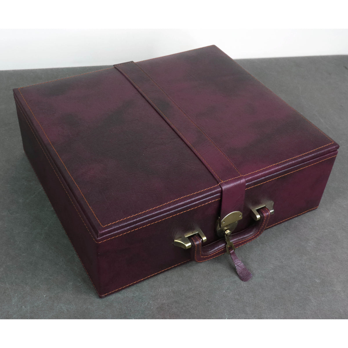 Closed luxury burgundy leatherette chess storage box showing top grain texture.