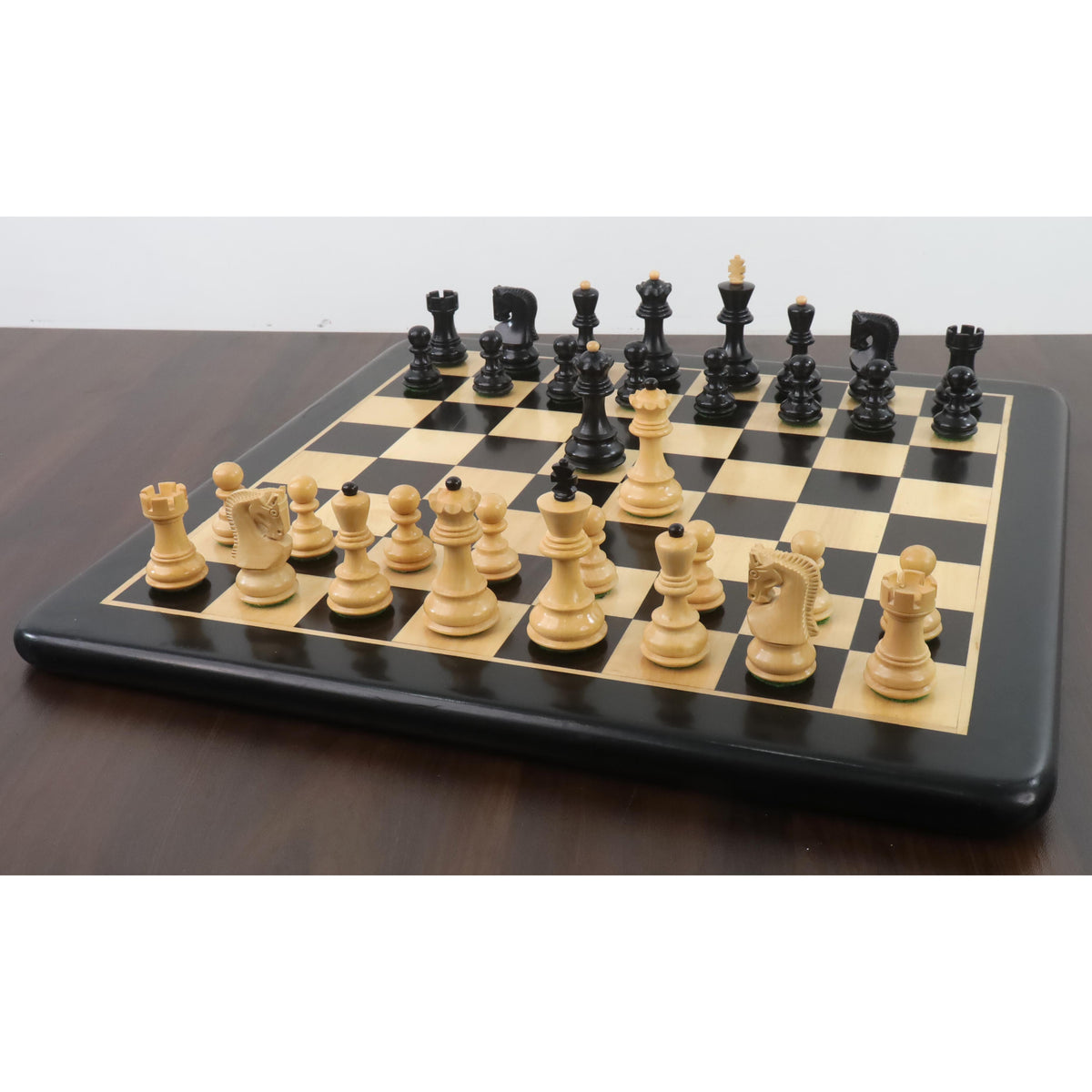 Weighted ebonised and natural boxwood Zagreb chess pieces set up on a luxury black and maple board.