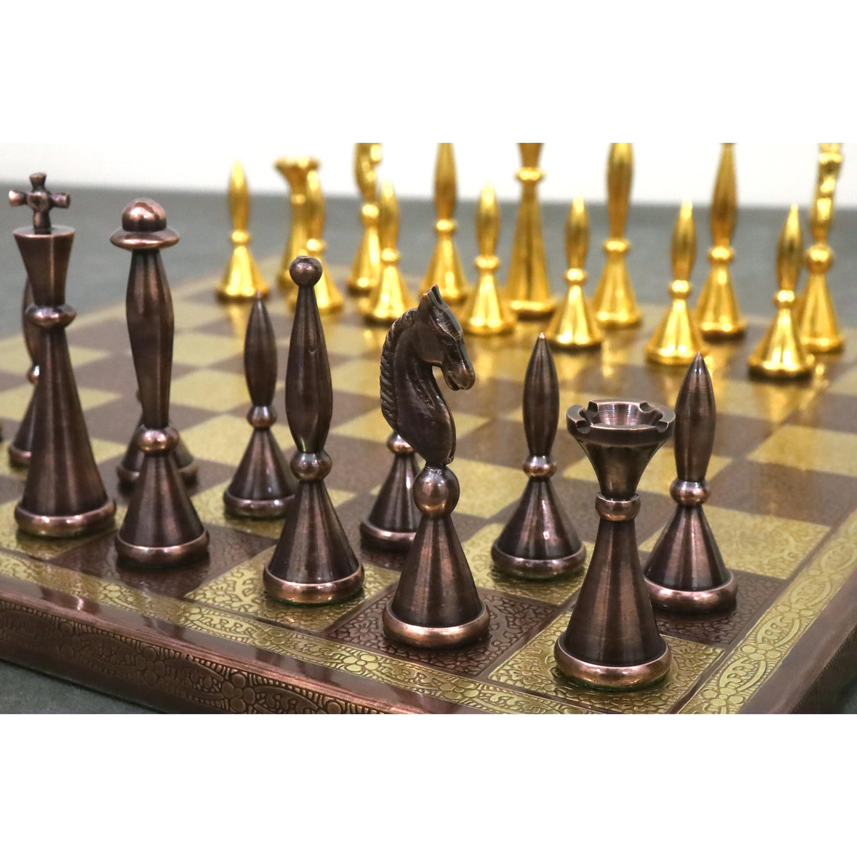 Antique copper brass chess pieces in sharp focus against a bokeh background of gold pieces.