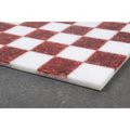 Detail of the seamless edge and polished finish of a red and white luxury stone chess board.